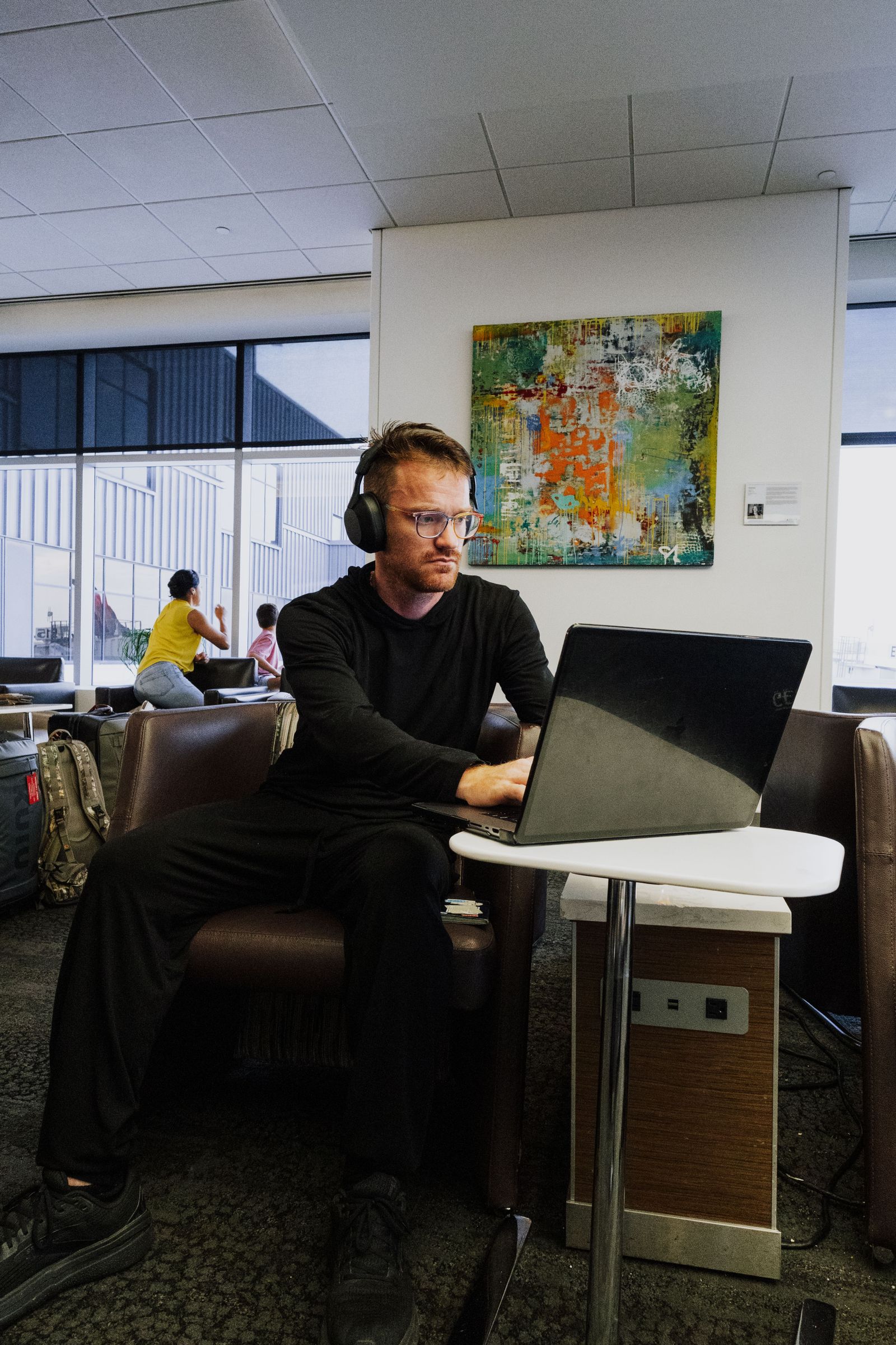 A business traveller working on a laptop in an airport lounge