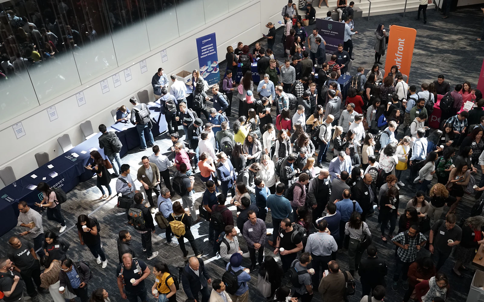 Business delegates networking at a conference reception in a bright lobby